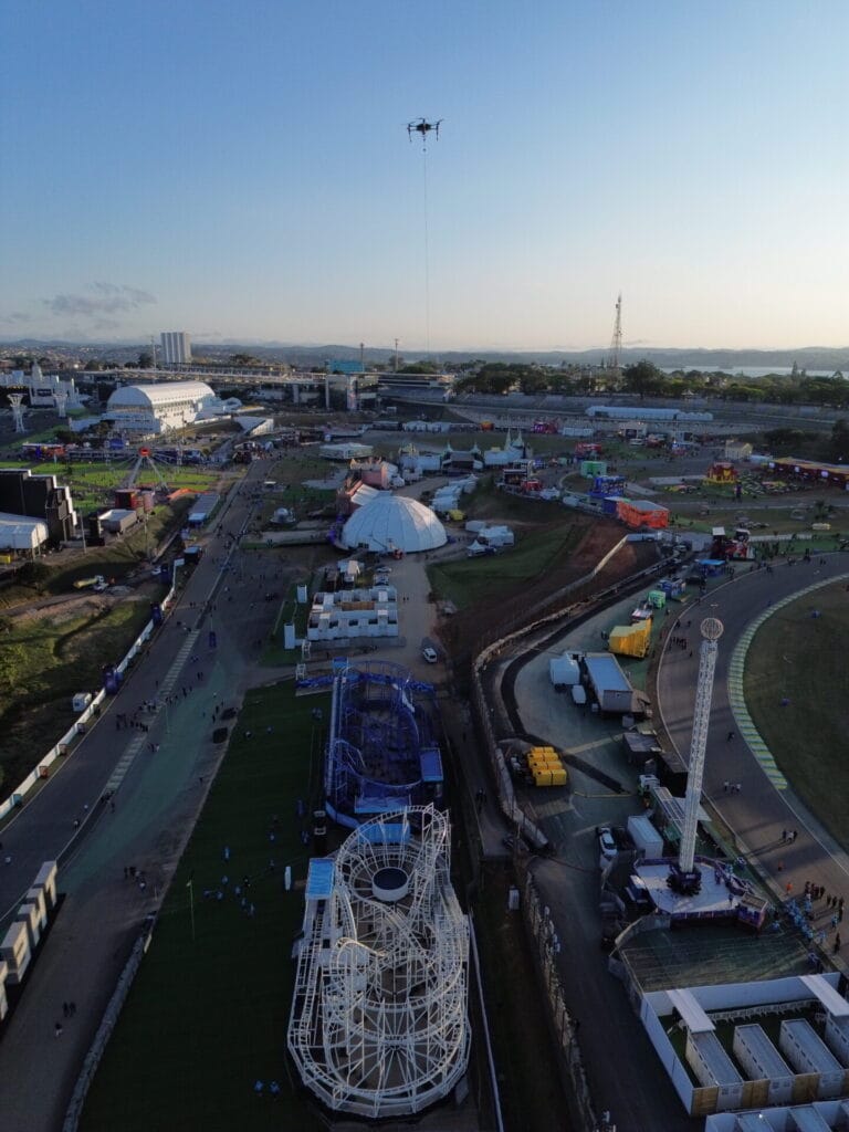 Vista aérea de um parque de diversões repleto de brinquedos, enquanto o céu limpo inspira os sonhos de mercado de Ôguen para 2025.